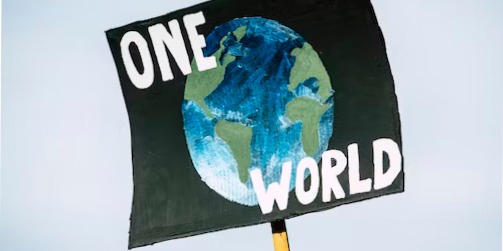 Auf dieser Darstellung ist ein Demonstrationsplakat zu erkennen, welches die Aufschrift One World trägt.